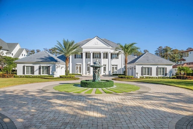greek revival house featuring curved driveway and a front yard