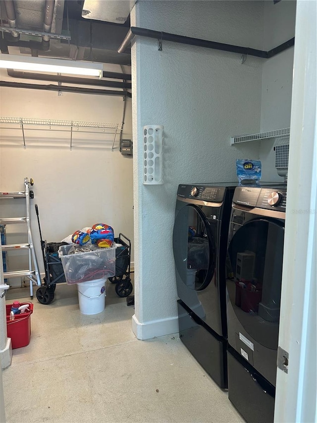 laundry room featuring laundry area, baseboards, and washing machine and dryer