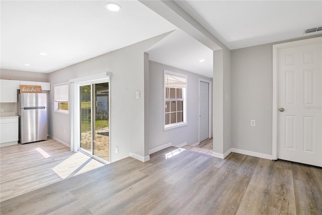 2927 Ahern Dr, Orlando, FL 32817 - unfurnished dining area with visible vents, light wood-style flooring, and baseboards