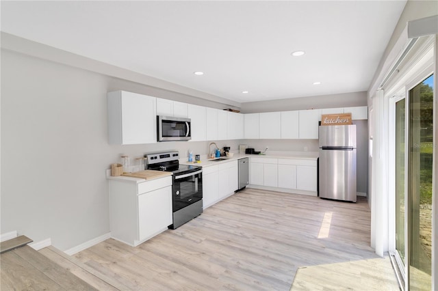 2927 Ahern Dr, Orlando, FL 32817 - kitchen with light wood finished floors, a sink, stainless steel appliances, white cabinets, and light countertops