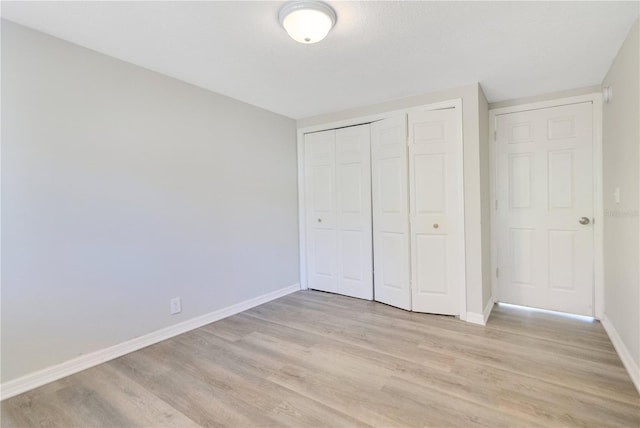2927 Ahern Dr, Orlando, FL 32817 - unfurnished bedroom with a closet, light wood-style floors, and baseboards
