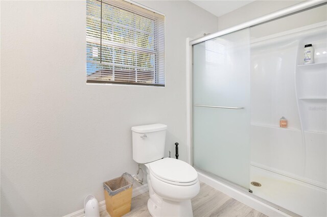 2927 Ahern Dr, Orlando, FL 32817 - bathroom with toilet, baseboards, a shower stall, and wood finished floors