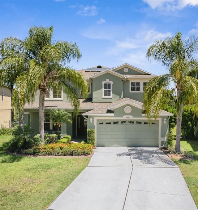 2842 Balforn Tower, Winter Garden, FL 34787 - view of front facade with an attached garage, solar panels, stucco siding, concrete driveway, and a front lawn