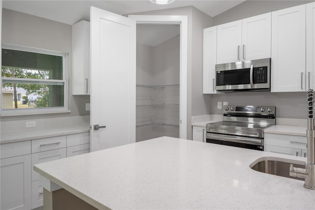 274 W Bolero Pl, Citrus Springs, FL 34434 - kitchen with stainless steel appliances, white cabinetry, and light stone counters