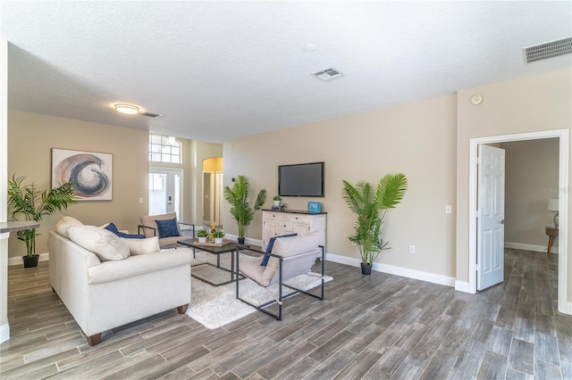 living room featuring visible vents, wood finished floors, and baseboards