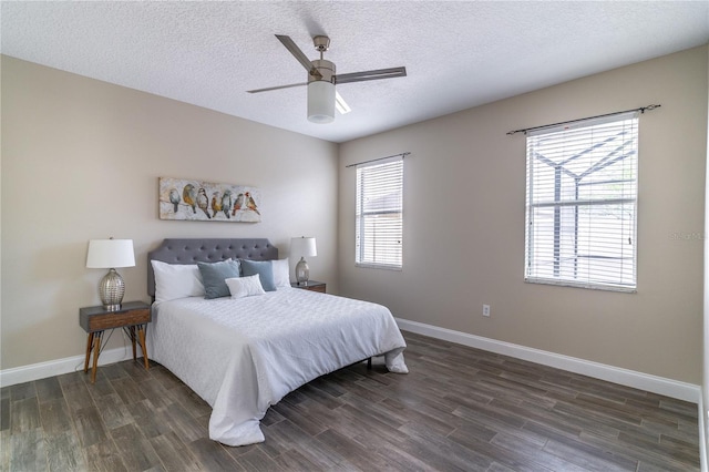 bedroom with a ceiling fan, dark wood-style flooring, baseboards, and a textured ceiling