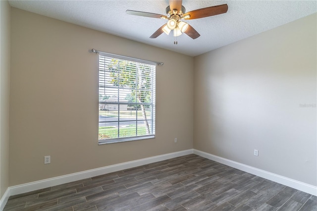 unfurnished room featuring dark wood finished floors, baseboards, and a ceiling fan