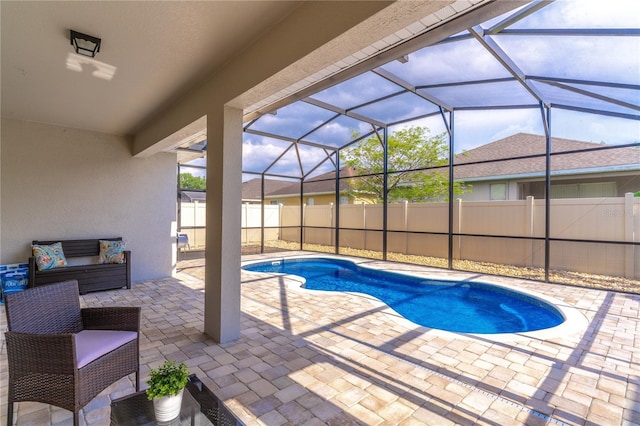 view of pool with fence, a patio, a fenced in pool, and a lanai