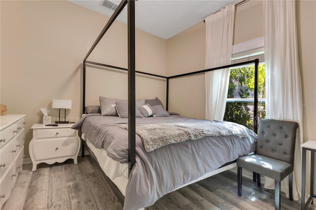 bedroom featuring visible vents and wood finished floors