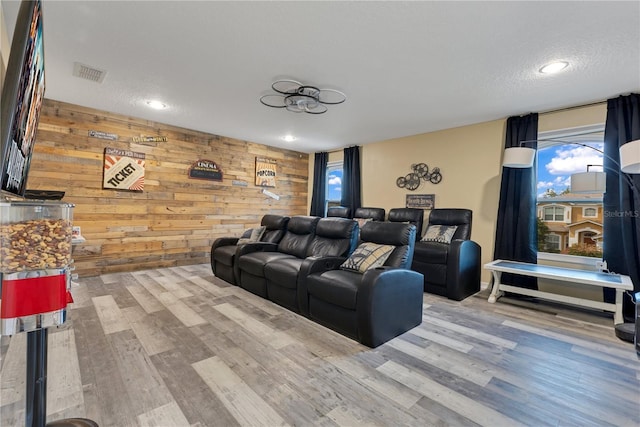 home theater featuring recessed lighting, wood walls, visible vents, and wood finished floors