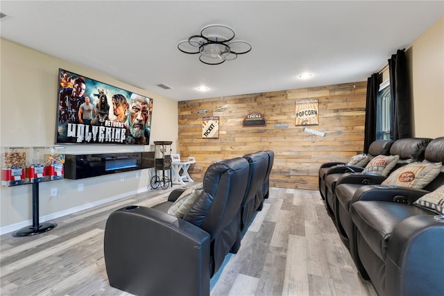 cinema room with wood walls, recessed lighting, and wood finished floors