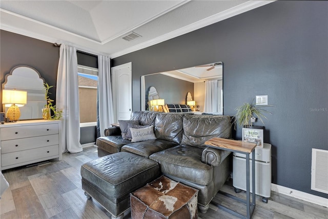 living room featuring ornamental molding, baseboards, visible vents, and wood finished floors