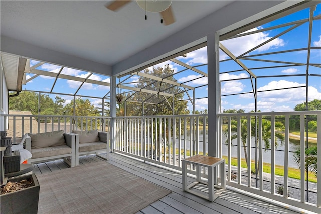 sunroom / solarium featuring a water view and ceiling fan