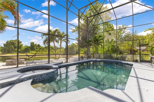 view of swimming pool featuring a patio area, a pool with connected hot tub, and a lanai