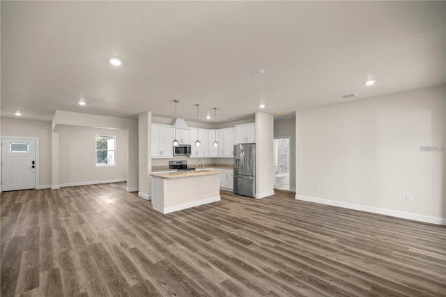 kitchen with appliances with stainless steel finishes, baseboards, open floor plan, and recessed lighting