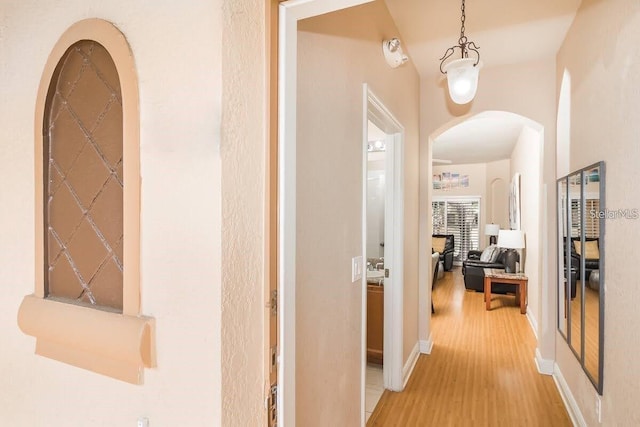 3643 Calabria Ave, Davenport, FL 33897 - hall with arched walkways, baseboards, and light wood-type flooring
