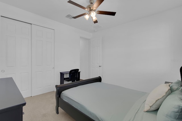 bedroom featuring light colored carpet, a closet, and a ceiling fan