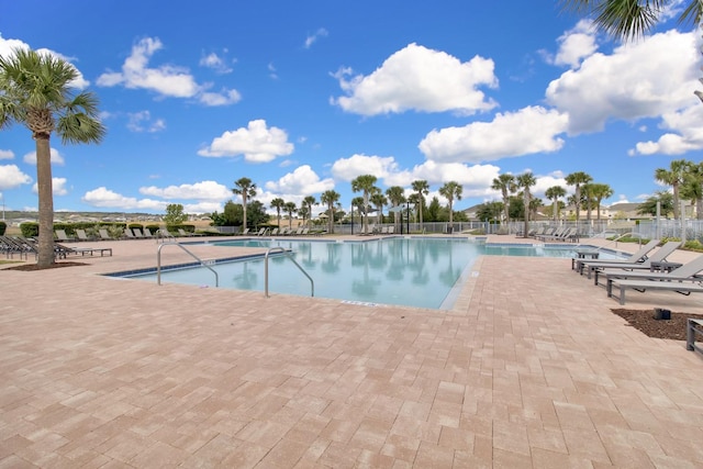 community pool featuring fence and a patio