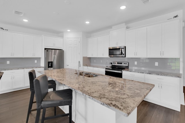 3017 Ambersweet Pl, Clermont, FL 34711 - kitchen featuring stainless steel appliances, a sink, a center island with sink, white cabinetry, and recessed lighting
