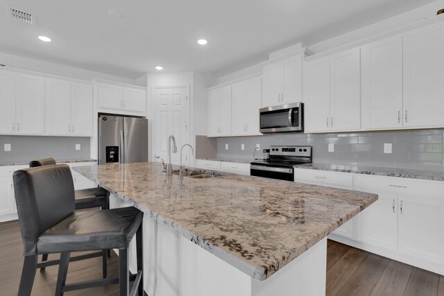 3017 Ambersweet Pl, Clermont, FL 34711 - kitchen with stainless steel appliances, a sink, recessed lighting, dark wood-style flooring, and white cabinetry