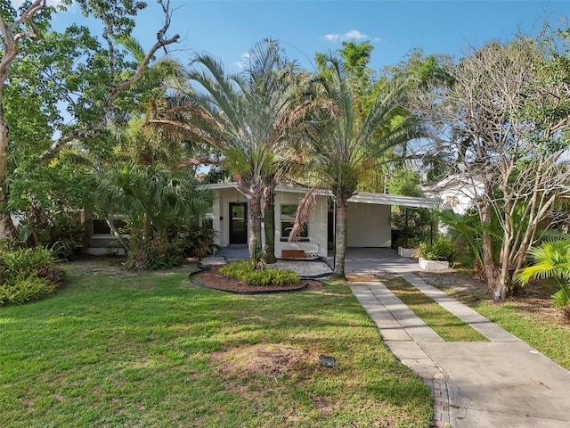 318 E Jersey St, Orlando, FL 32806 - view of front of house with driveway, a front lawn, an attached carport, and stucco siding