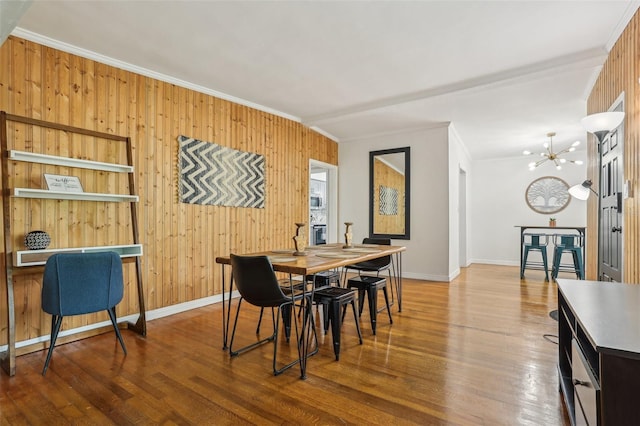 318 E Jersey St, Orlando, FL 32806 - dining area featuring crown molding, a chandelier, wooden walls, baseboards, and wood finished floors