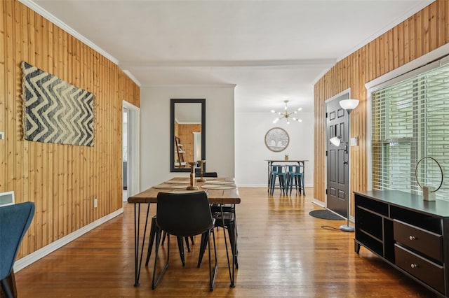 318 E Jersey St, Orlando, FL 32806 - dining room with wood walls, crown molding, wood finished floors, a chandelier, and baseboards