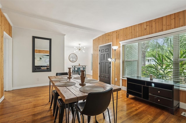 318 E Jersey St, Orlando, FL 32806 - dining space featuring healthy amount of natural light, dark wood-style flooring, a chandelier, wood walls, and ornamental molding