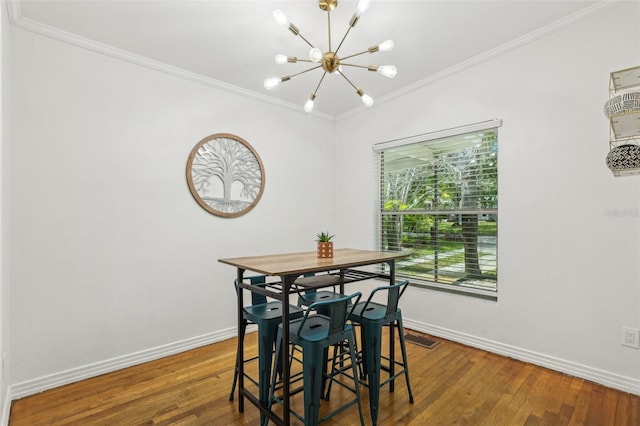 318 E Jersey St, Orlando, FL 32806 - dining space featuring crown molding, a chandelier, baseboards, and wood finished floors