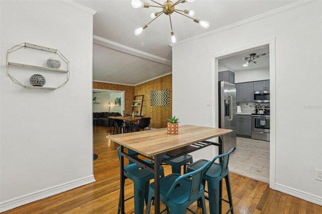318 E Jersey St, Orlando, FL 32806 - dining space featuring a chandelier, ornamental molding, wood finished floors, wood walls, and baseboards