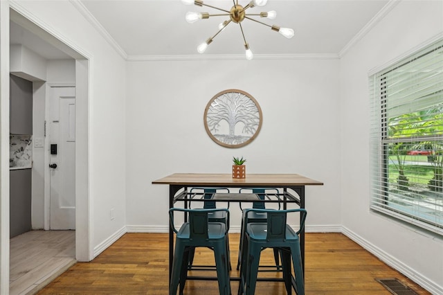 318 E Jersey St, Orlando, FL 32806 - dining space featuring a chandelier, crown molding, wood finished floors, and baseboards