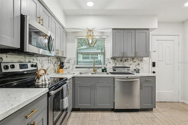 318 E Jersey St, Orlando, FL 32806 - kitchen with appliances with stainless steel finishes, gray cabinets, a sink, backsplash, and recessed lighting