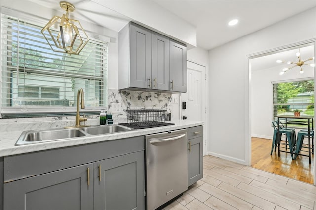 318 E Jersey St, Orlando, FL 32806 - kitchen with gray cabinets, a chandelier, stainless steel dishwasher, a sink, and light countertops