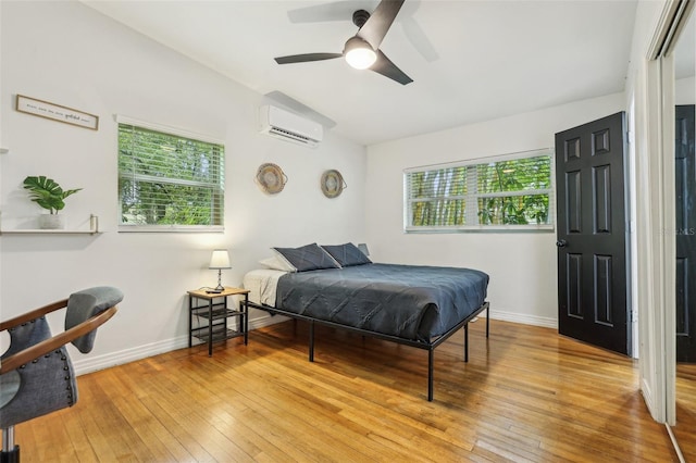 318 E Jersey St, Orlando, FL 32806 - bedroom with light wood finished floors, a wall mounted air conditioner, baseboards, and ceiling fan