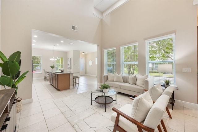 14244 Walcott Ave, Orlando, FL 32827 - living room featuring light tile patterned flooring, a towering ceiling, a chandelier, and recessed lighting