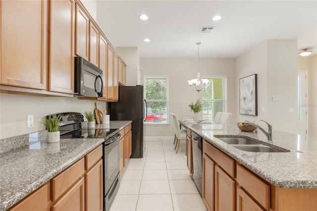 14244 Walcott Ave, Orlando, FL 32827 - kitchen featuring black appliances, a center island with sink, a chandelier, light tile patterned flooring, and light stone counters