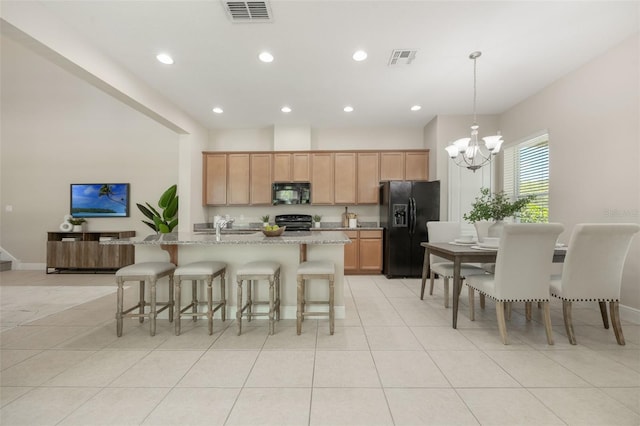 14244 Walcott Ave, Orlando, FL 32827 - kitchen with black appliances, a chandelier, a kitchen bar, recessed lighting, and light tile patterned flooring