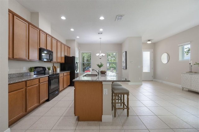 14244 Walcott Ave, Orlando, FL 32827 - kitchen featuring black appliances, a breakfast bar, recessed lighting, a chandelier, and stone countertops