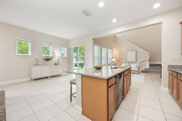 14244 Walcott Ave, Orlando, FL 32827 - kitchen with open floor plan, light tile patterned flooring, dishwashing machine, a kitchen bar, and light stone counters