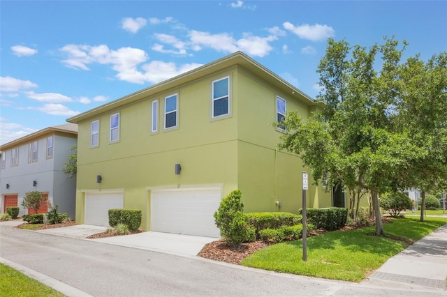 14244 Walcott Ave, Orlando, FL 32827 - view of home's exterior with a garage, stucco siding, driveway, and a lawn