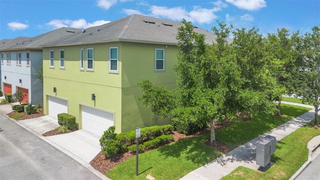 14244 Walcott Ave, Orlando, FL 32827 - view of home's exterior featuring a garage, concrete driveway, stucco siding, and a shingled roof