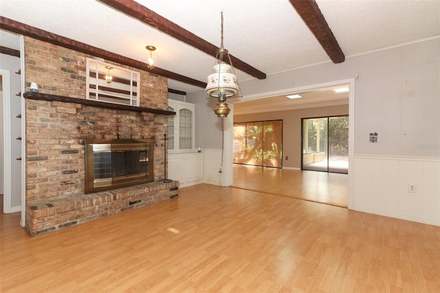 4141 Fallwood Cir, Orlando, FL 32812 - unfurnished living room with wood finished floors, beam ceiling, a brick fireplace, a decorative wall, and a wainscoted wall