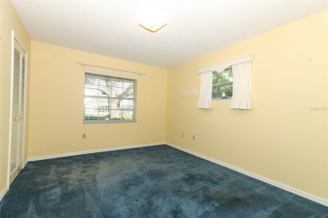 4141 Fallwood Cir, Orlando, FL 32812 - unfurnished bedroom featuring multiple windows, dark carpet, and baseboards