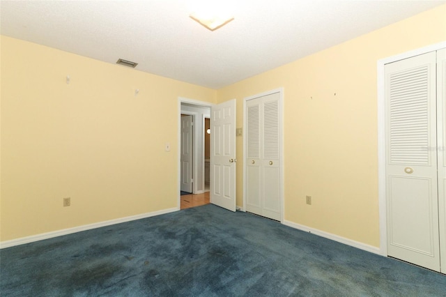 4141 Fallwood Cir, Orlando, FL 32812 - unfurnished bedroom with two closets, dark colored carpet, and baseboards