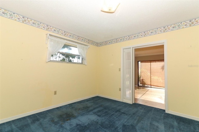 4141 Fallwood Cir, Orlando, FL 32812 - empty room featuring dark colored carpet, healthy amount of natural light, and baseboards
