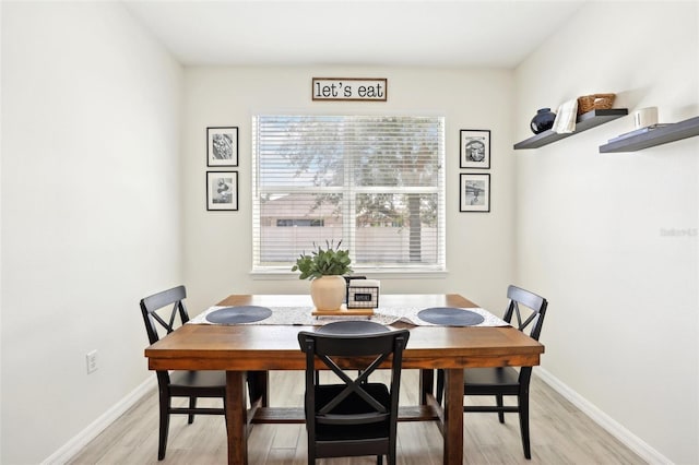 dining room featuring light wood finished floors and baseboards