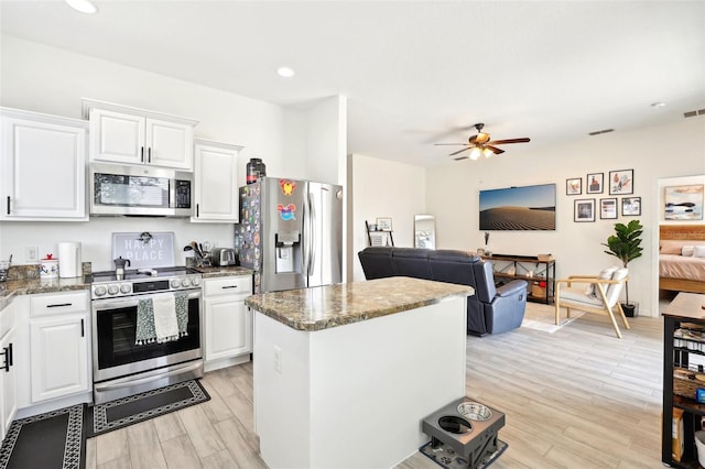 kitchen with appliances with stainless steel finishes, ceiling fan, open floor plan, a center island, and recessed lighting