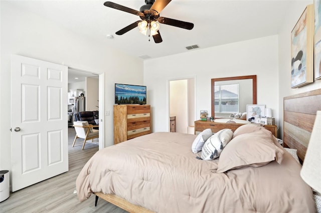bedroom featuring light wood-style floors, ceiling fan, and freestanding refrigerator