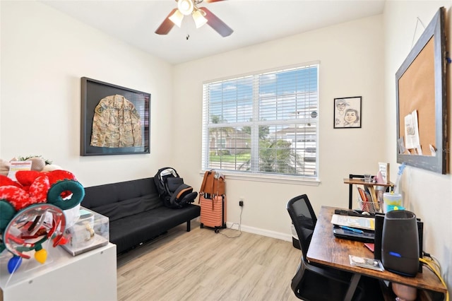 home office with light wood finished floors, a ceiling fan, and baseboards