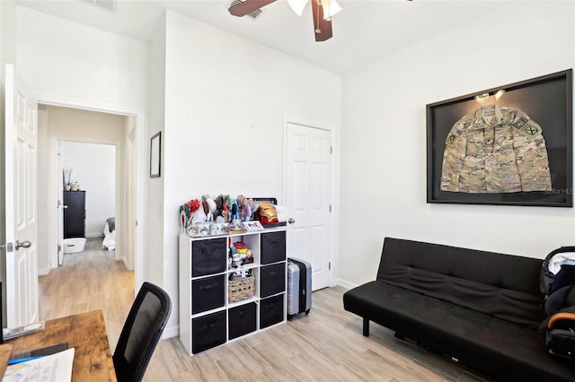 sitting room featuring a ceiling fan, wood finished floors, and baseboards